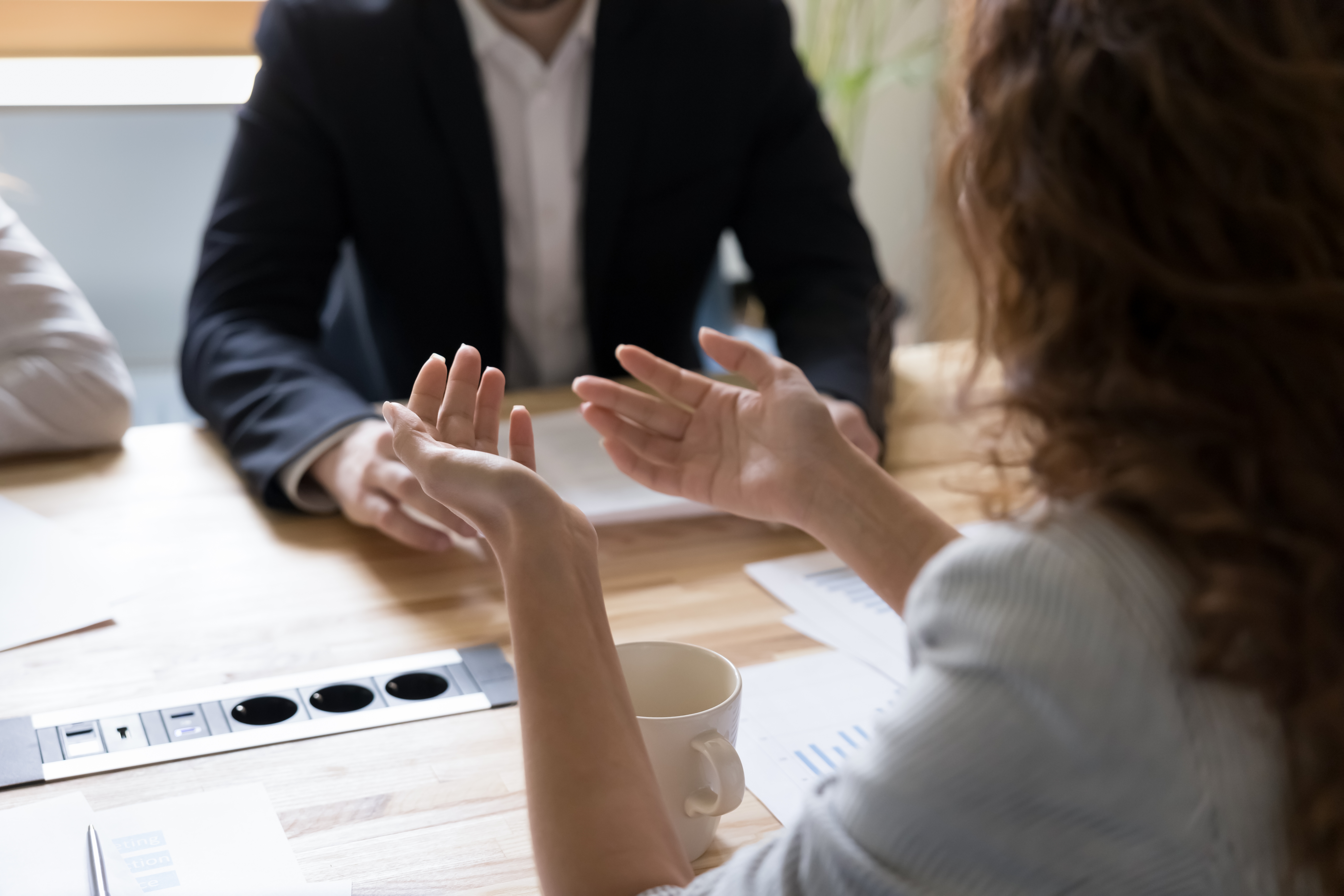 Twee mensen in een B2B-onderhandeling aan tafel, waar belangen, waarde en resultaat centraal staan in plaats van alleen prijs